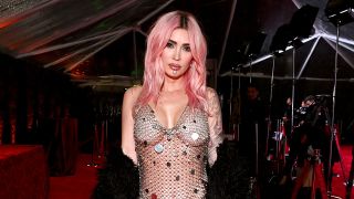 Megan Fox in chain link dress with flare on red carpet in 2024.