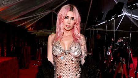 Megan Fox in chain link dress with flare on red carpet in 2024. 