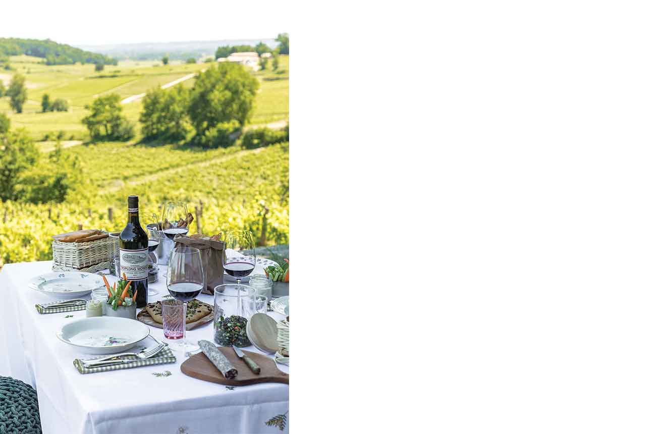 dining table set up outside with vineyards in background