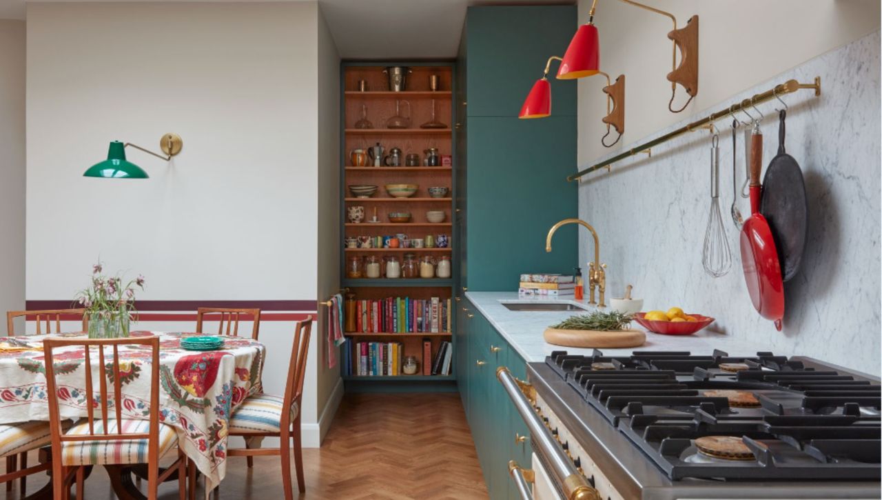 Green and white kitchen with open shelving and wooden dining table