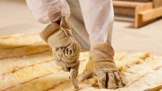 Man cutting insulation material for building construction