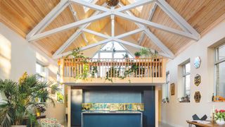 large chapel conversion with exposed beams and blue kitchen