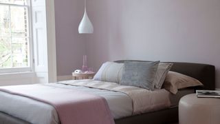 modern lilac painted bedroom with a minimalist approach to decorating highlighting key bedroom trend for most popular colors