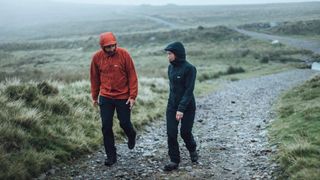 A man and a woman hiking wearing softshell jackets