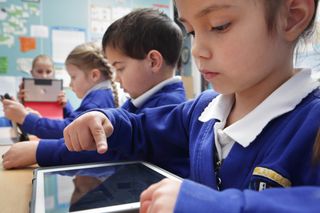 Children in school working on tablets