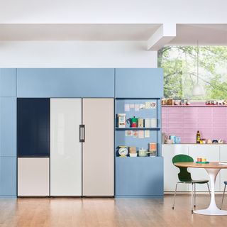 a bespoke samsung fridge freezer in a bright colourful kitchen with pink accents and blue cabinetry