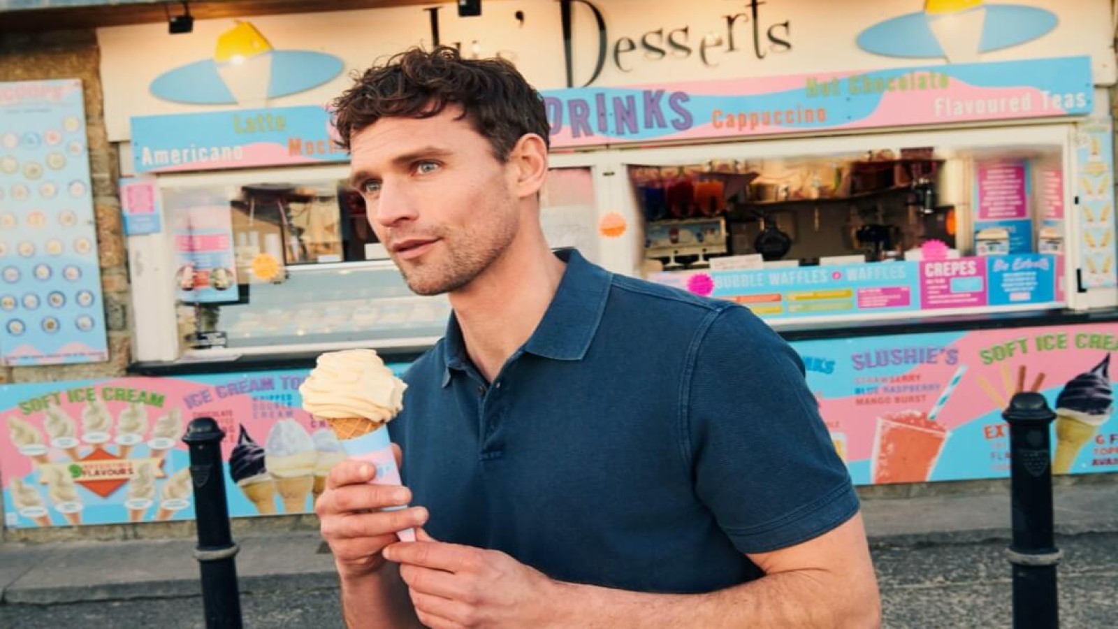 A man eating an ice cream in a blue polo shirt