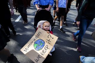 A baby clutches a sign during a climate strike rally on Sept. 20, 2019, in Sydney, Australia, part of a global mass day of action on the climate crisis.