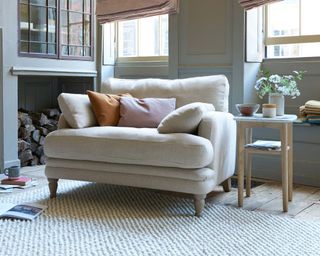 comfy beige armchair with cushions and a side table
