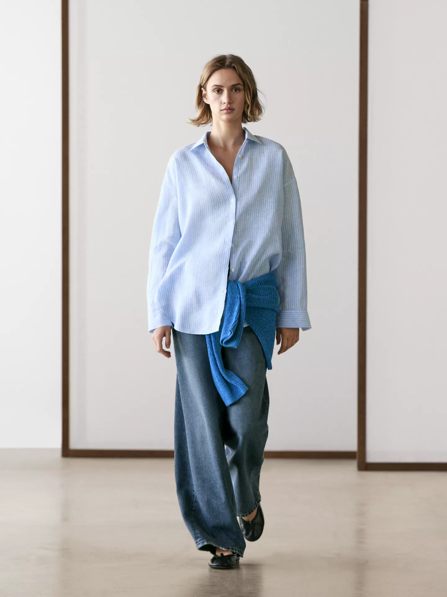 A model wearing a Massimo Dutti blue striped shirt.