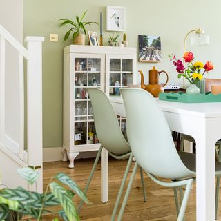 green dining room with white table and green chairs