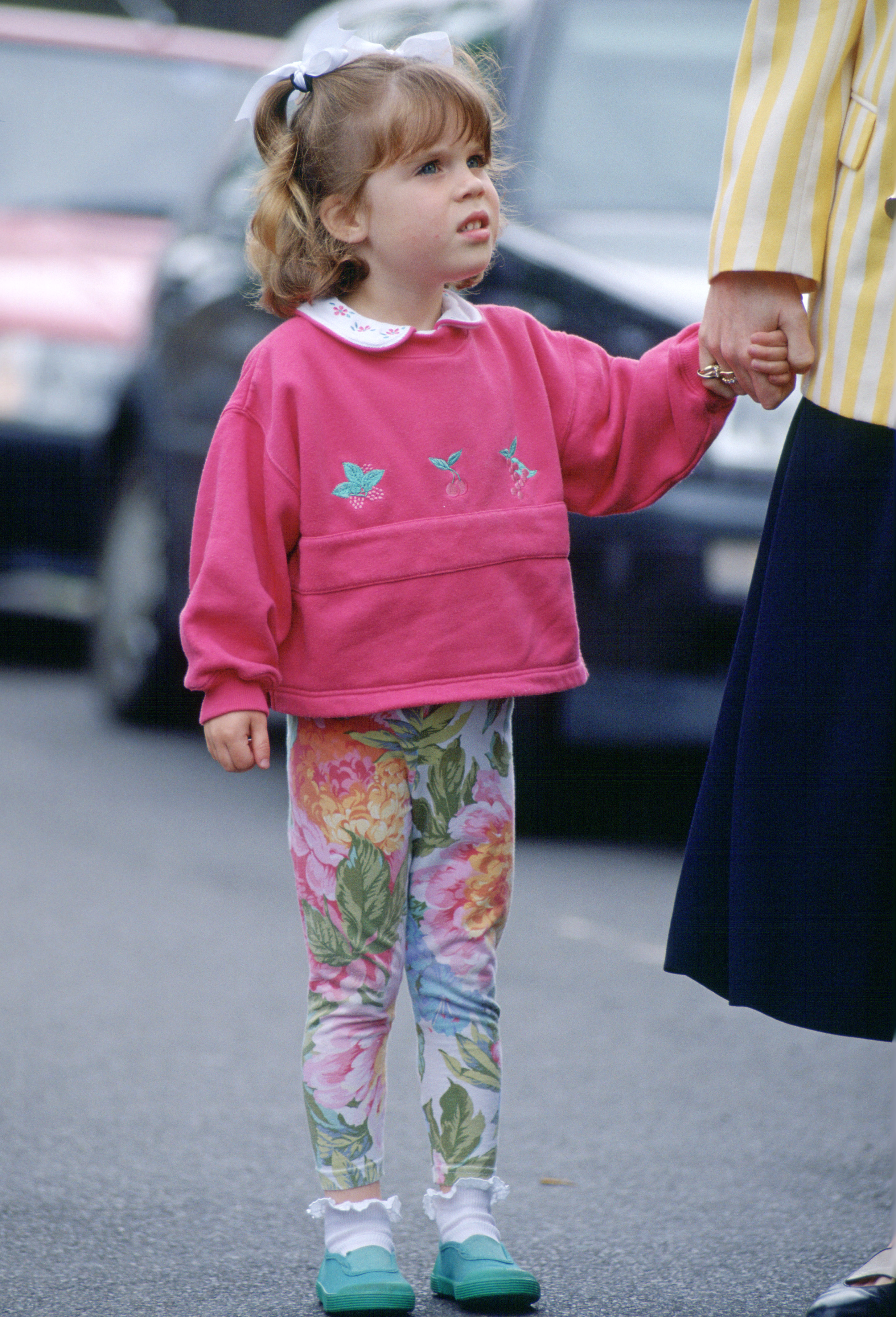 Princess Eugenie holds hands with mom Sarah Ferguson in June 1994, while wearing floral leggings and a pink sweatshirt, showing she's a royal style inspiration for Princess Lilibet