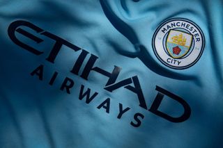 The Manchester City club crest displaying Etihad Airways as the shirt sponsor on a first team shirt on April 24, 2020 in Manchester, England 