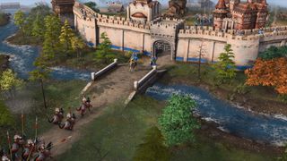 En hær i Age of Empires IV krysser en bor på vei mot en fiende-festning.