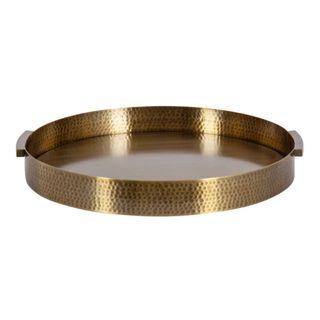 A circular hammered gold tray