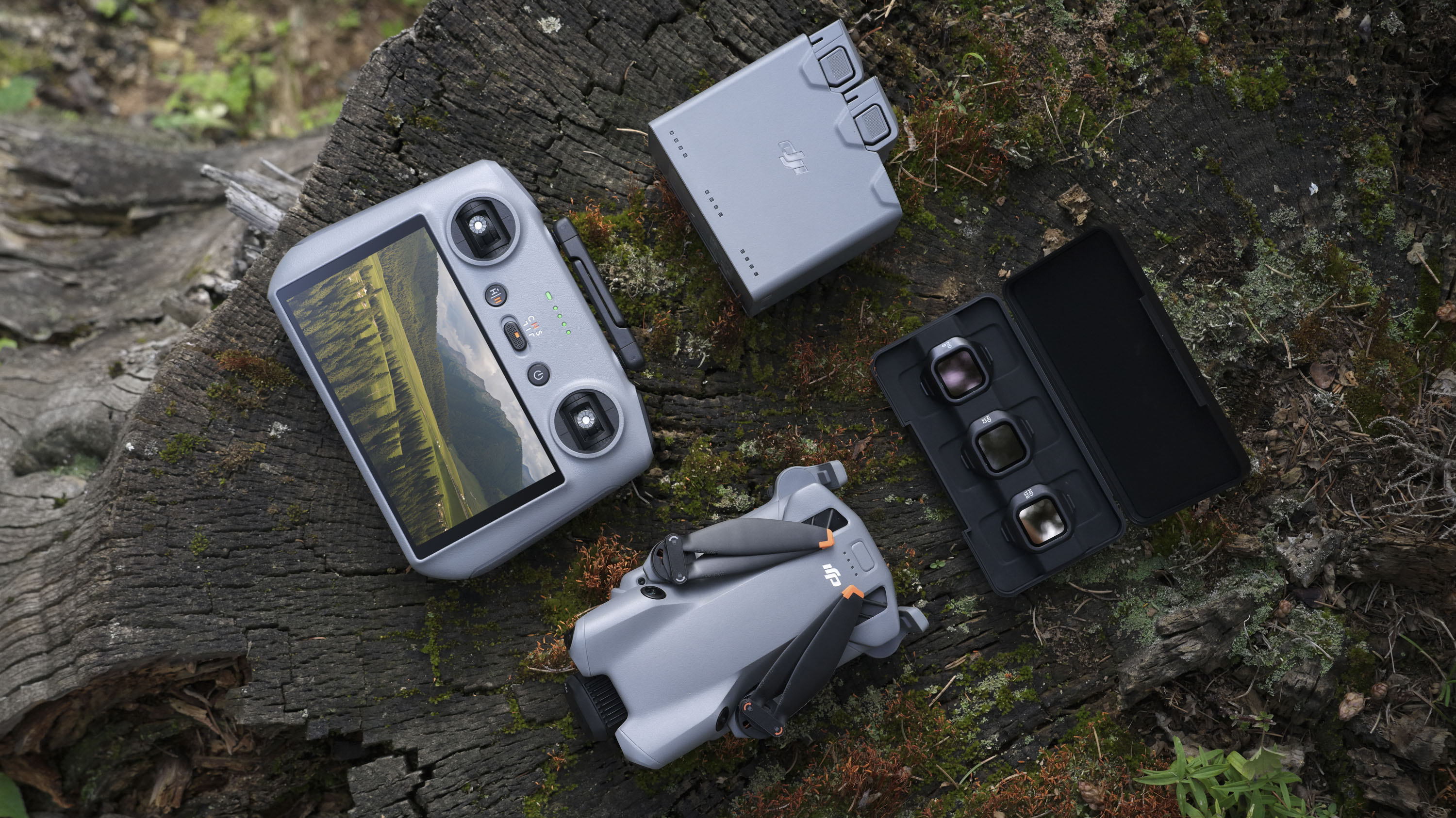 DJI Mini 5 ProFly More Combo kit (RC 2) laid out on a tree stump