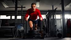 A man performing the sled push at a gym