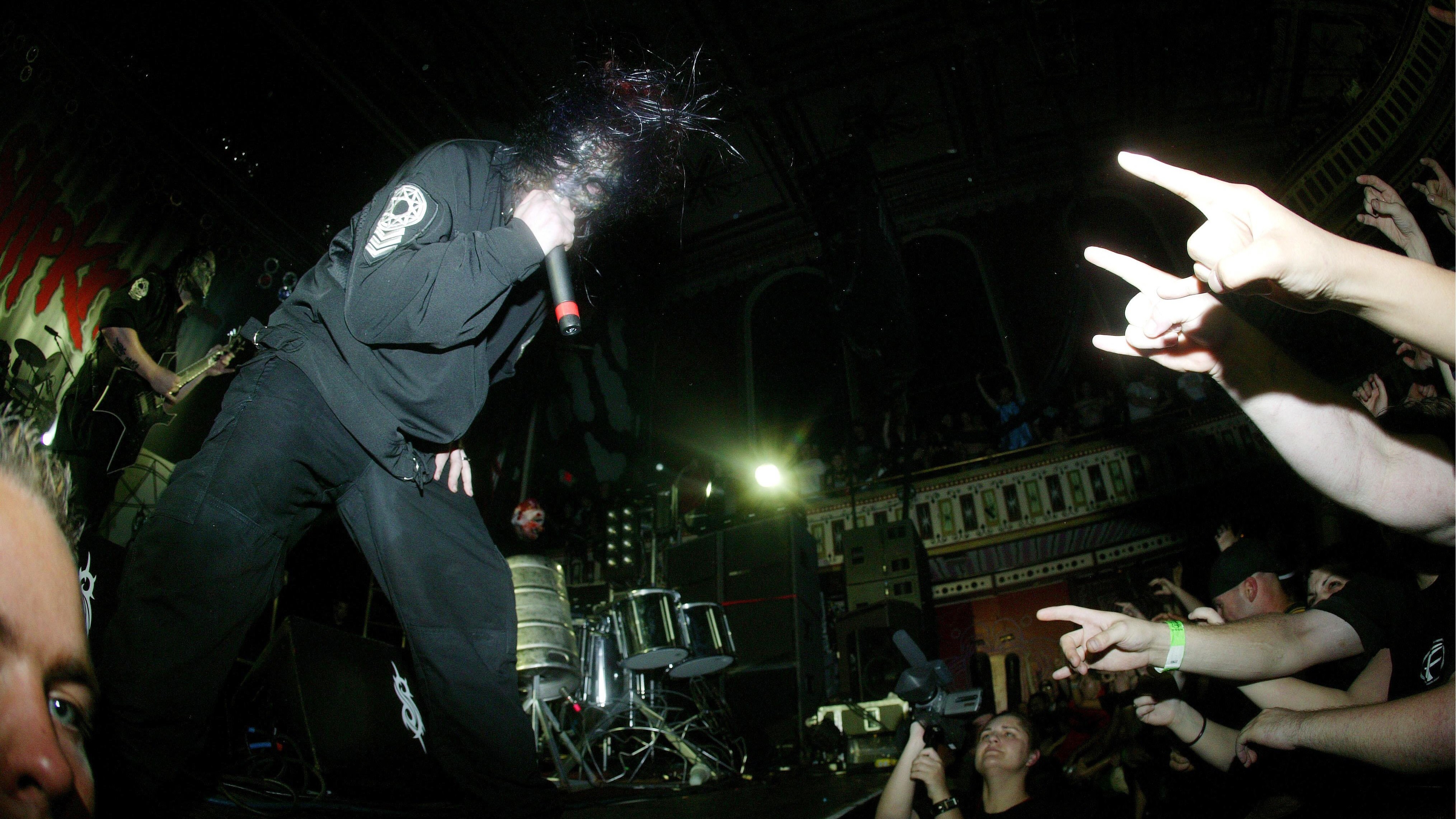 Mick Thomson (L) Corey Taylor performing on stage, audience hands, video camera