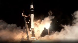 a black and white rocket launches at night