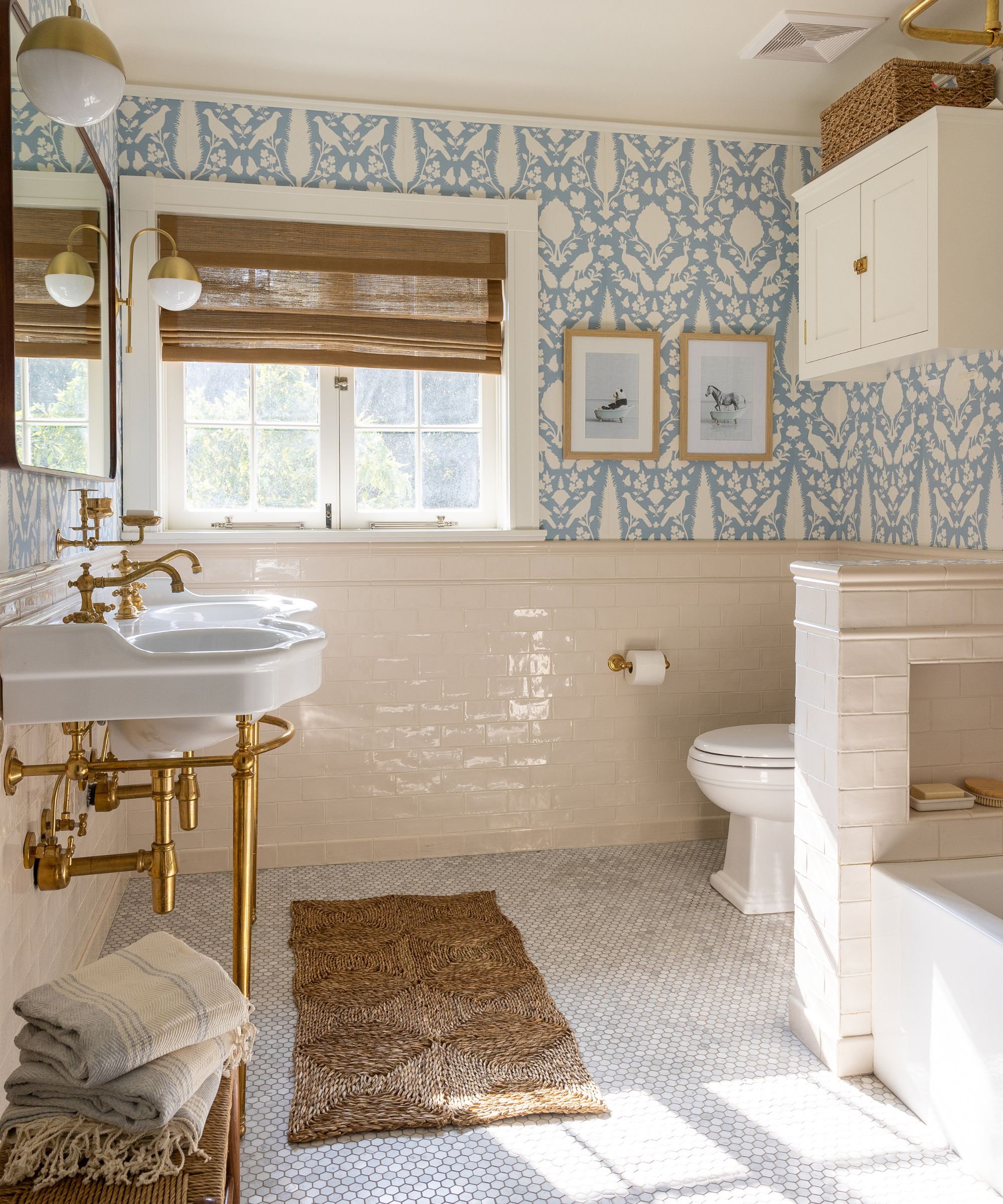 neutral coastal bathroom with blue patterned wallpaper and rattan accents