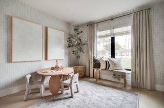 A small playroom with a round table and chairs, plus a bay window