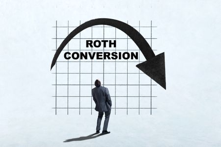 A man looks up as he ponders the benefits of making a Roth Conversion.