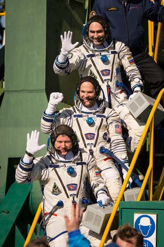 Expedition 33/34 crew members, Soyuz Commander Oleg Novitskiy, bottom, Flight Engineer Kevin Ford of NASA, and Flight Engineer Evgeny Tarelkin of ROSCOSMOS, top, wave farewell before boarding their Soyuz rocket just a few hours before their launch to the International Space Station on Tuesday, October 23, 2012, in Baikonur, Kazakhstan.