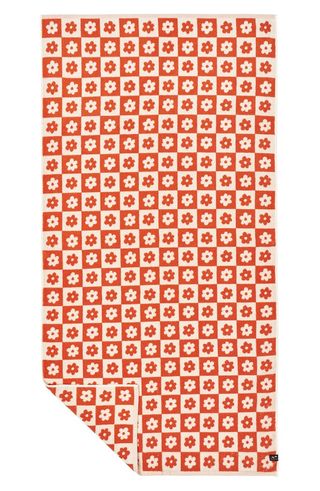 an orange and white floral beach towel
