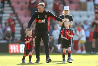Bournemouth manager Eddie Howe celebrates on the pitch with his sons Harry and Rocky