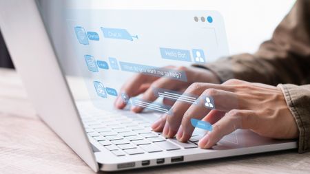 Hands typing on a keyboard, with digital text and symbols superimposed on top showing a conversation with a chatbot