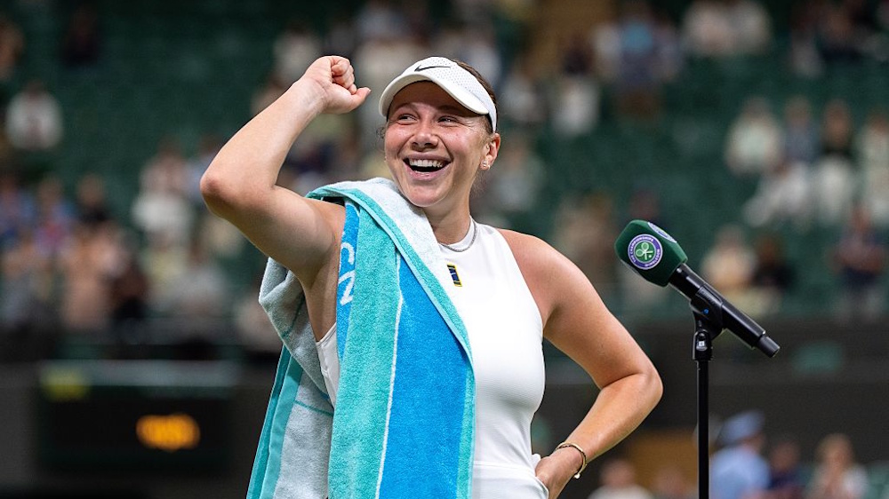 Amanda Anisimova smiling while giving a post-match interview after winning a match at Wimbledon 2025.