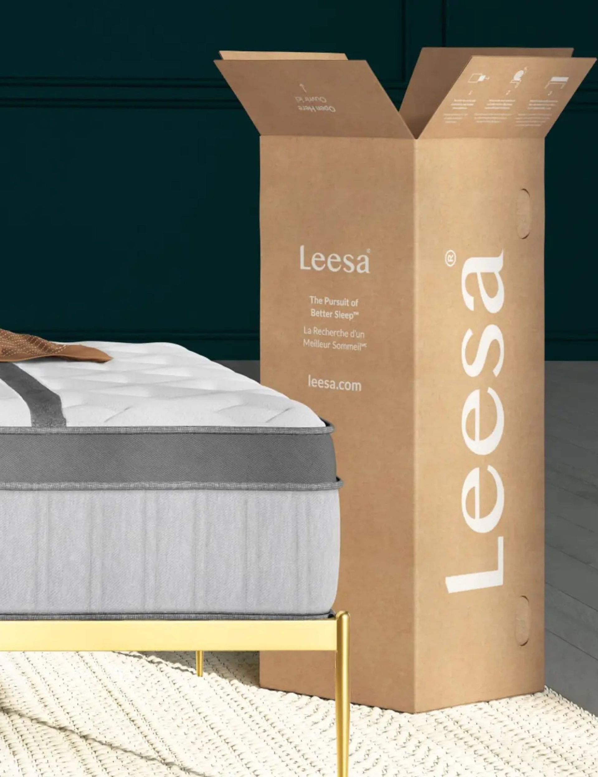 A Leesa mattress next to an open brown cardboard box