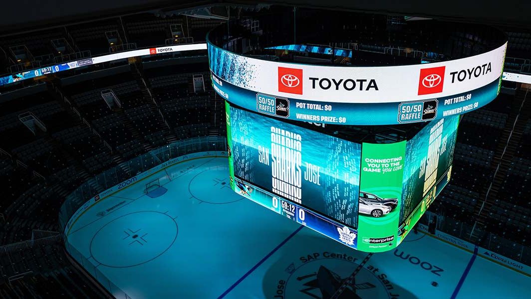 A new centerhung system illuminated in blues and greens with detailed hockey action hangs at the NHL&#039;s San Jose Sharks arena courtesy of Daktronics. 