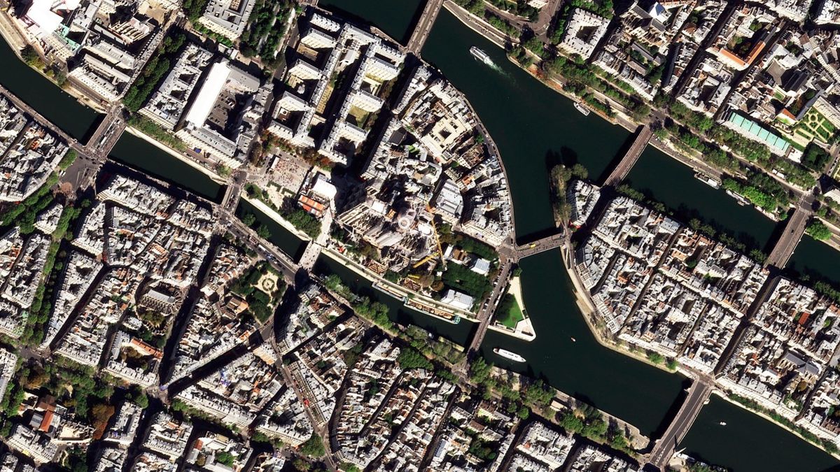 An aerial view of Paris, showing the Notre Dame covered in scaffolding