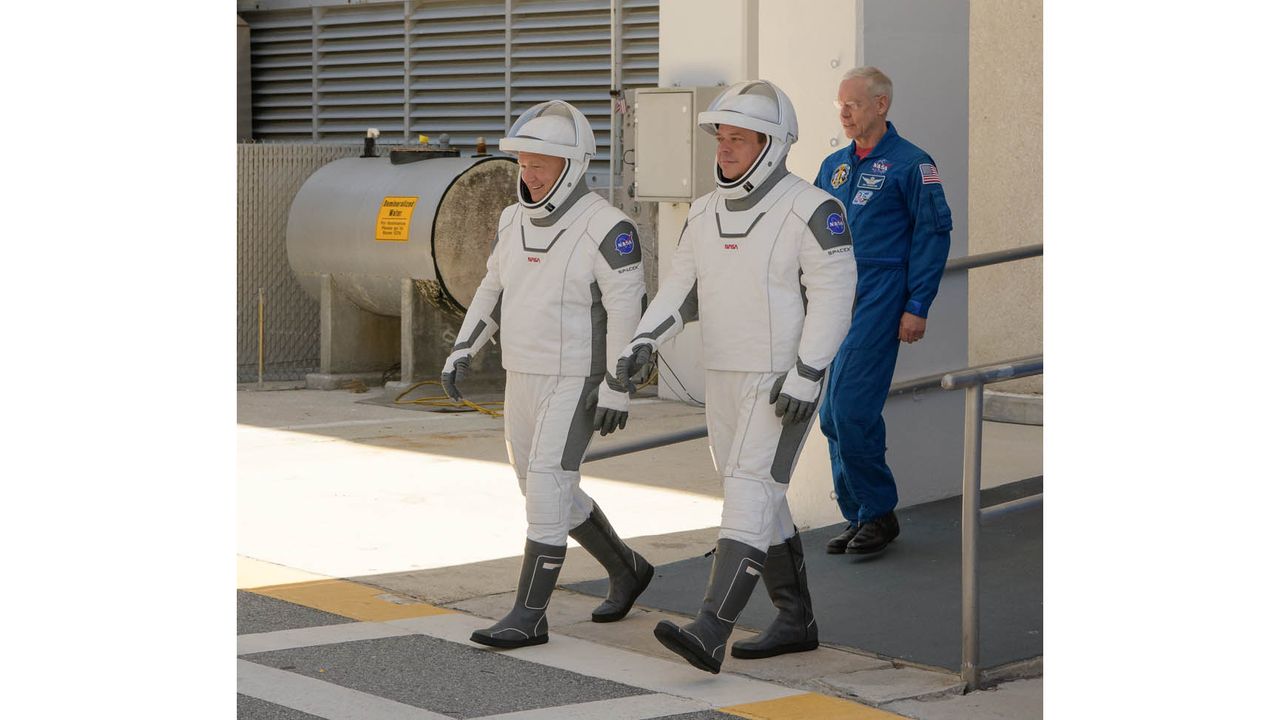 NASA astronauts Bob Behnken and Doug Hurley walk out of NASA's Astronaut Crew Quarters and take a Tesla Model X to Launch Pad 39A during a dry-run test of their SpaceX Crew Dragon Demo-2 flight on May 23, 2020 at the Kennedy Space Center in Florida.