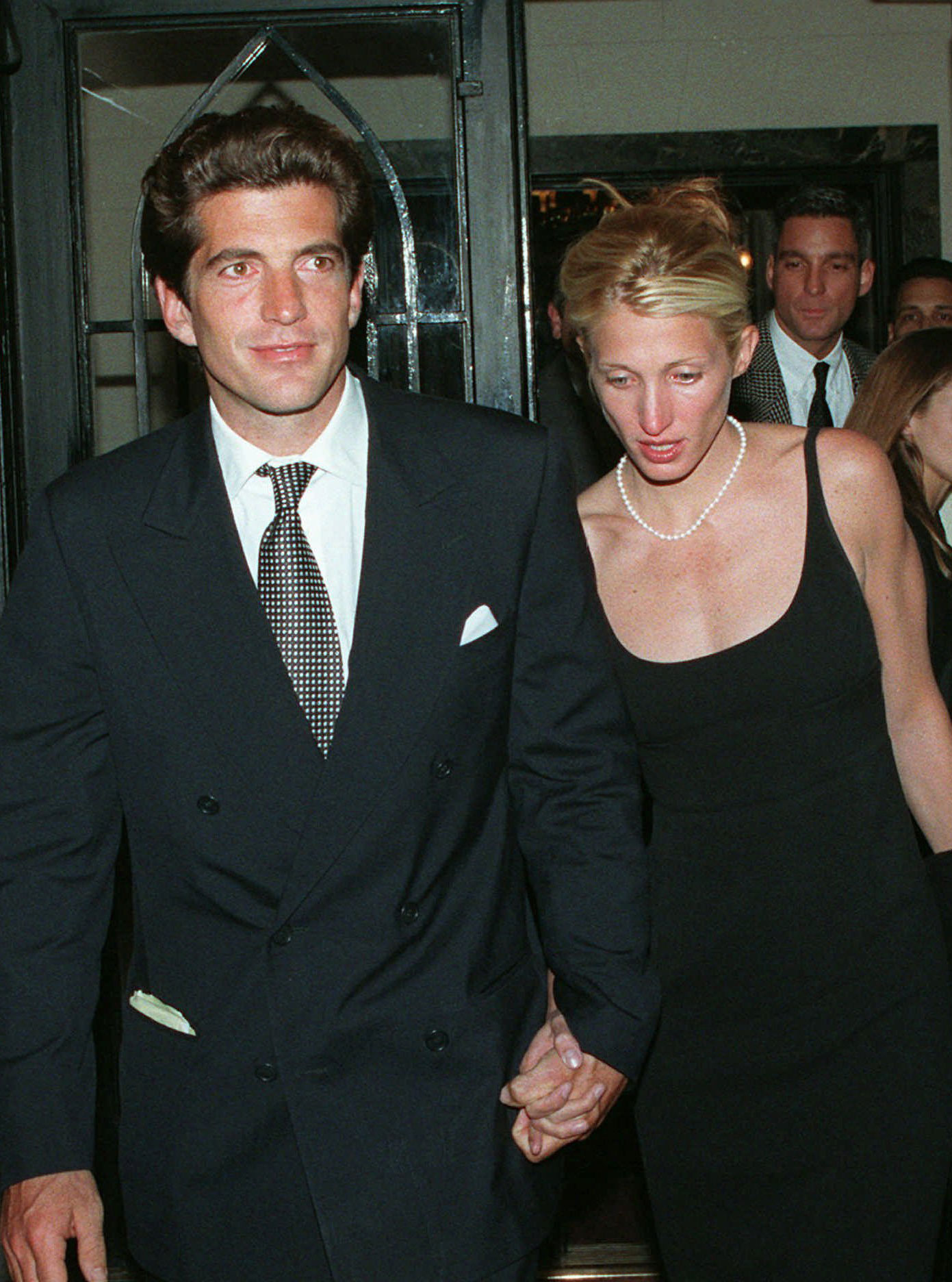 Carolyn Bessette Kennedy wears a pearl necklace with JFK, Jr.