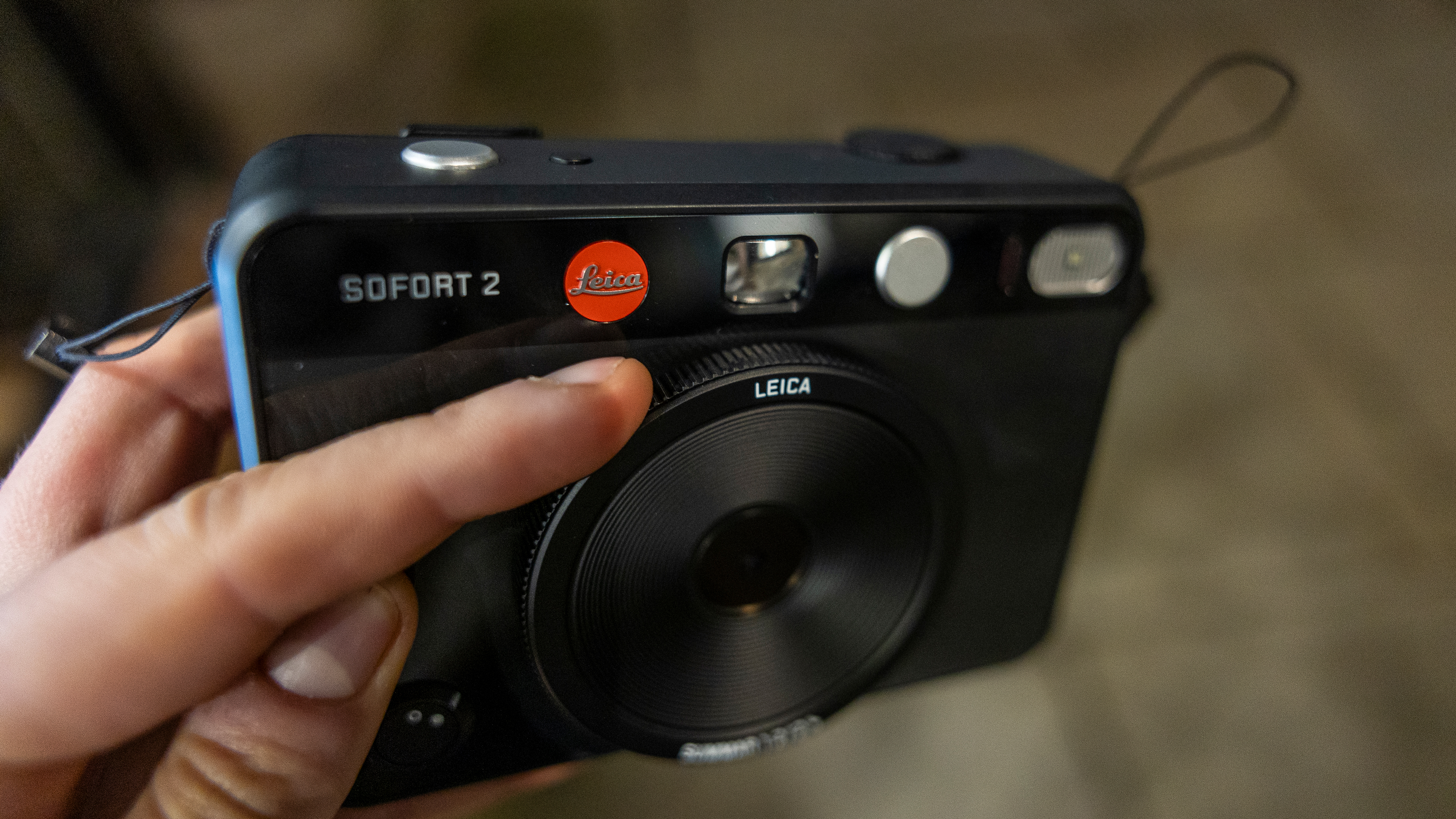 The Leica Sofort 2 lens being twisted to change filters
