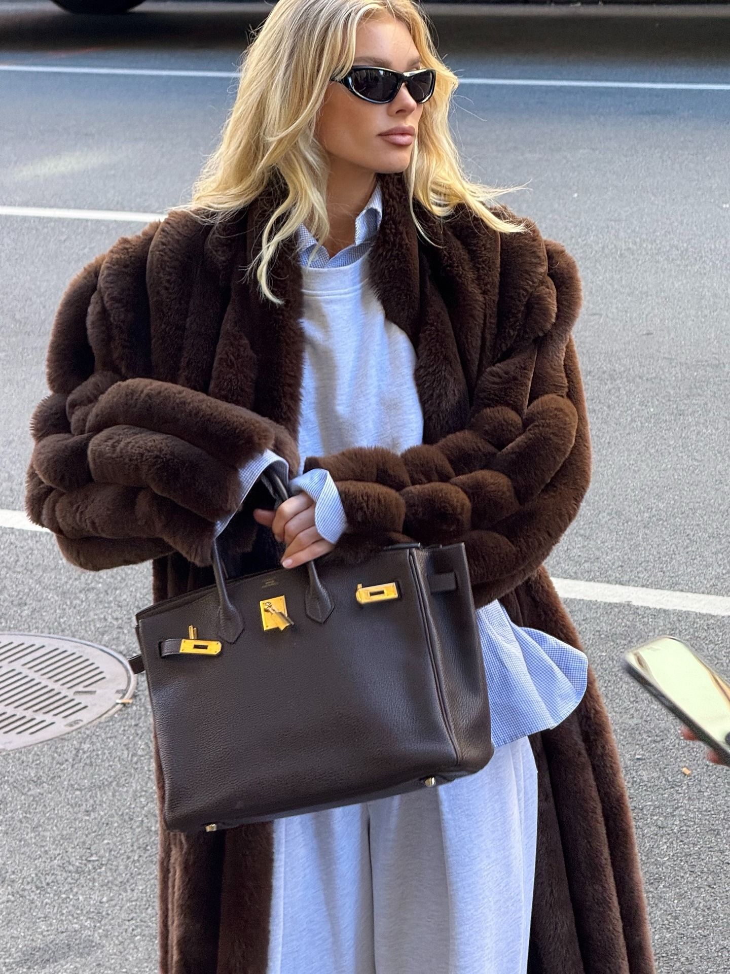 Elsa Hosk wearing gray sweatpants, a matching sweatshirt, and a long brown fur coat with a Birkin bag.