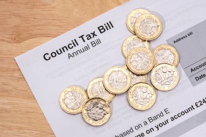 UK one pound coins placed on a Council Tax Bill