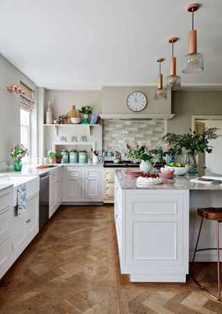 Kitchen with white cabinets and aga with island parquet floor and Georgian sash windows