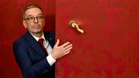 Herbert Kickl emerging from behind an upholstered red door in Vienna's Hofburg Palace 