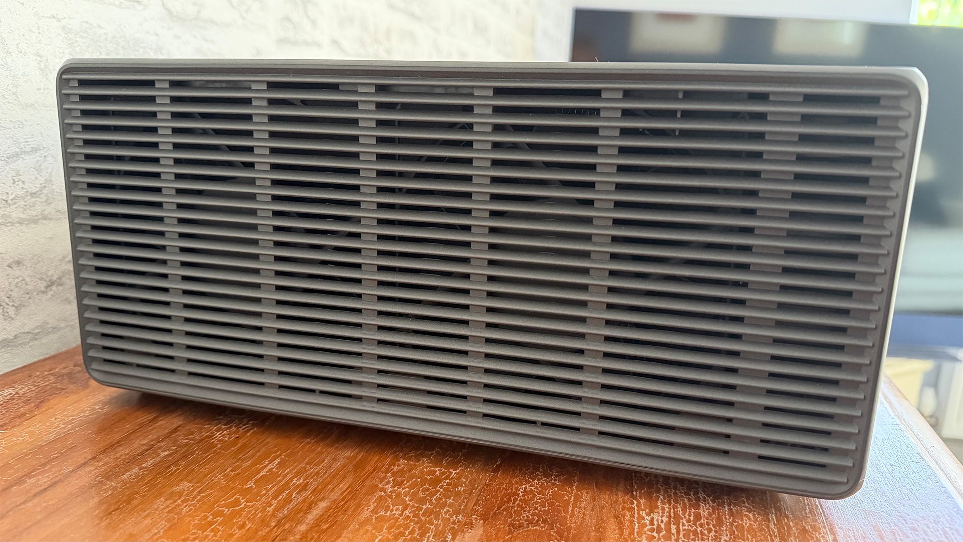 Xgimi Titan home cinema projector on wooden surface, showing grille on side of unit