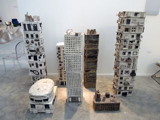 Display of buildings built out of plastic crates and paper