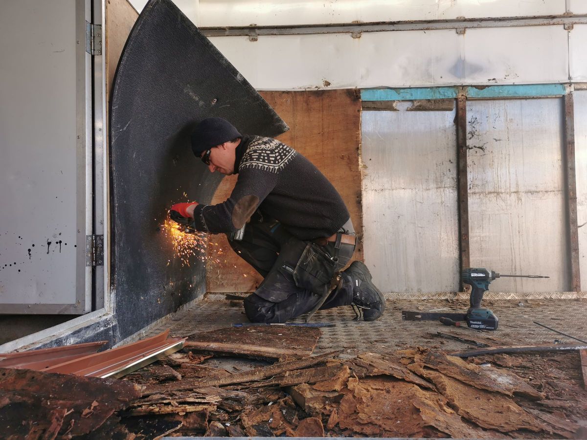 The flooring inside being stripped back using a grinder