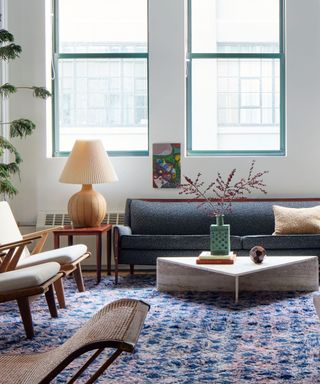 A living room full of vintage furniture and a textured dark blue rug