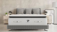 Plushbeds mattress on a bed against gray walls.