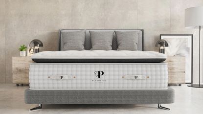 Plushbeds mattress on a bed against gray walls.