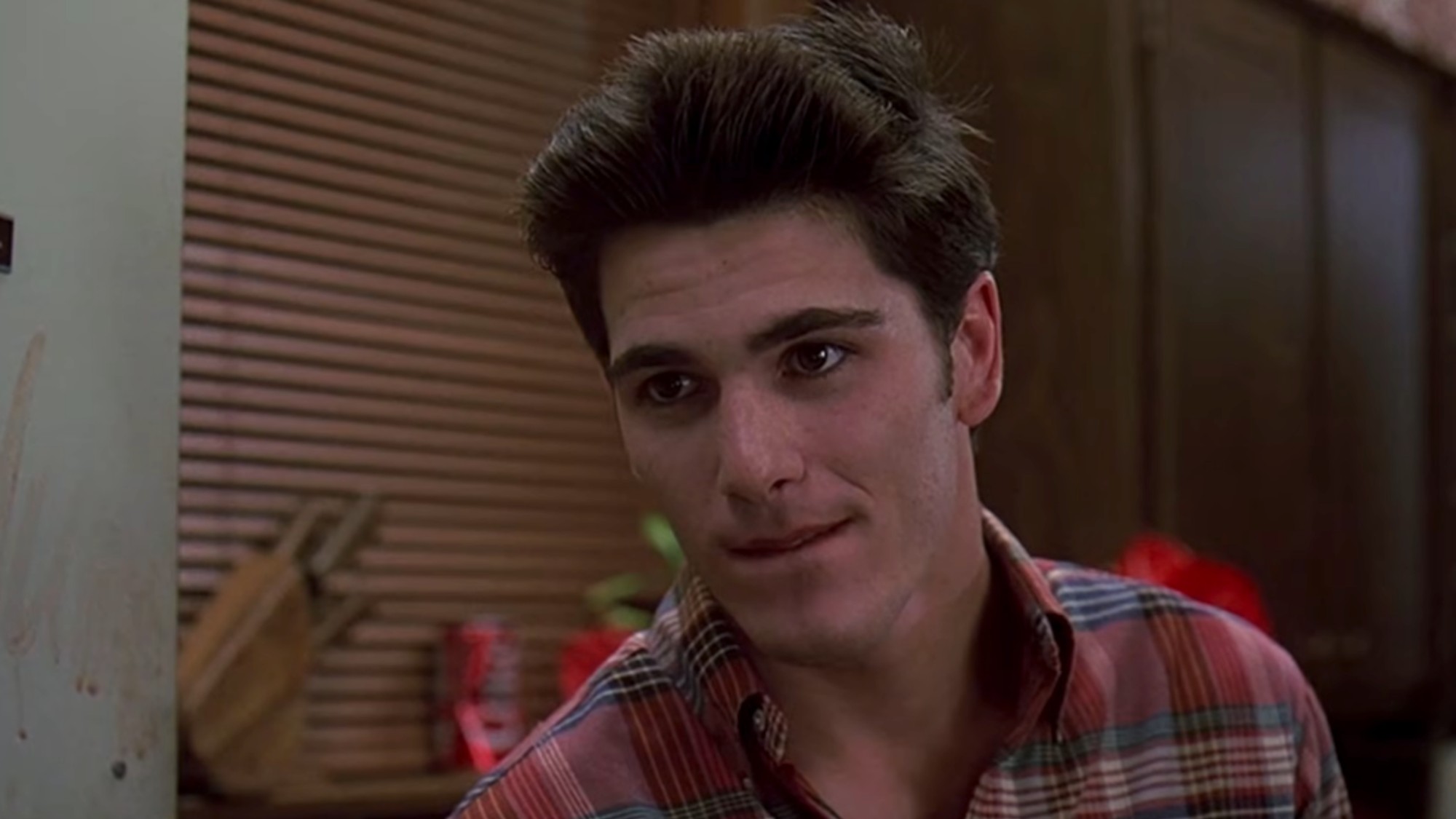 Michael Schoeffling with a plaid shirt on in close up in Sixteen Candles