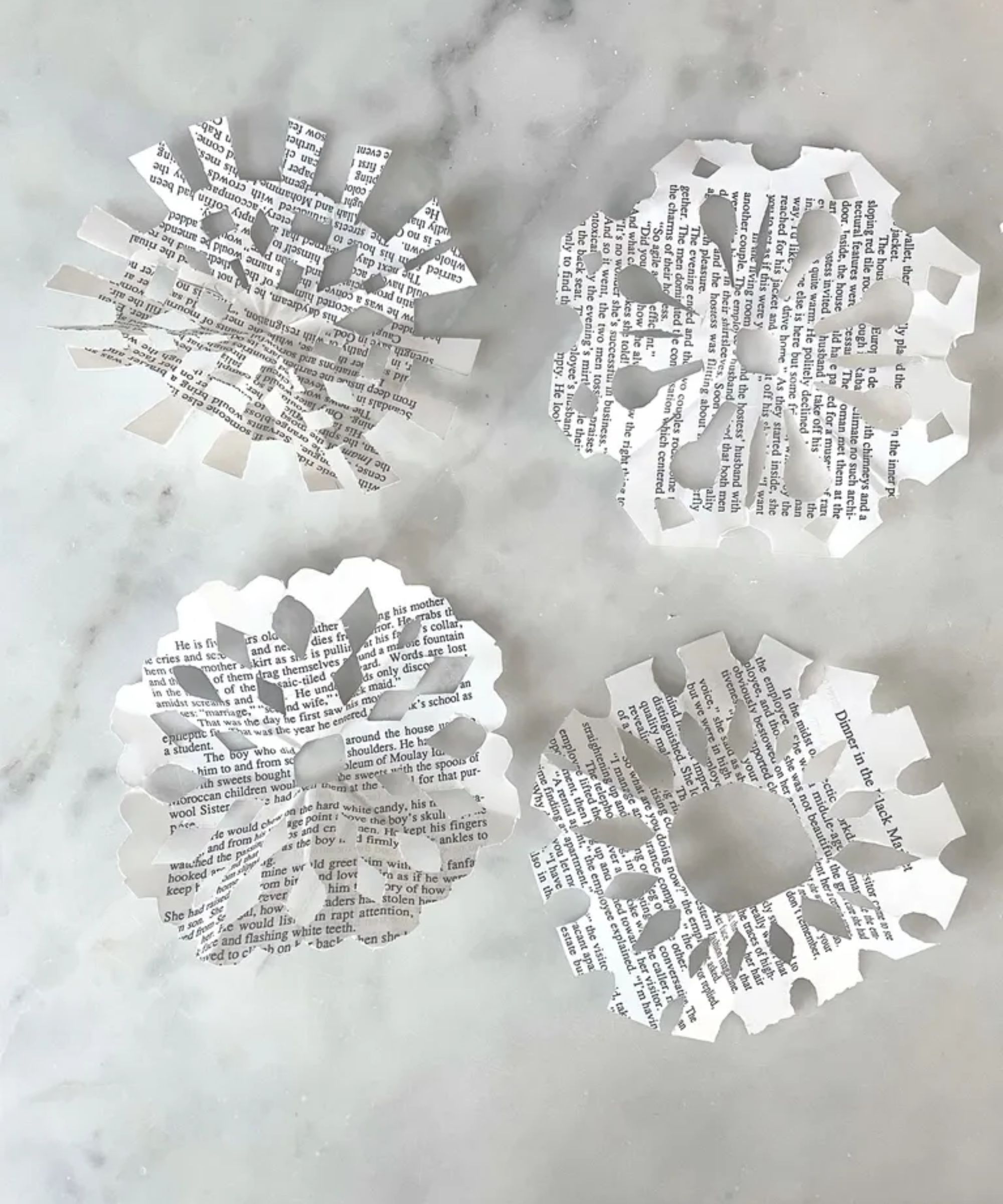 Newspaper snowflakes on a white marble background