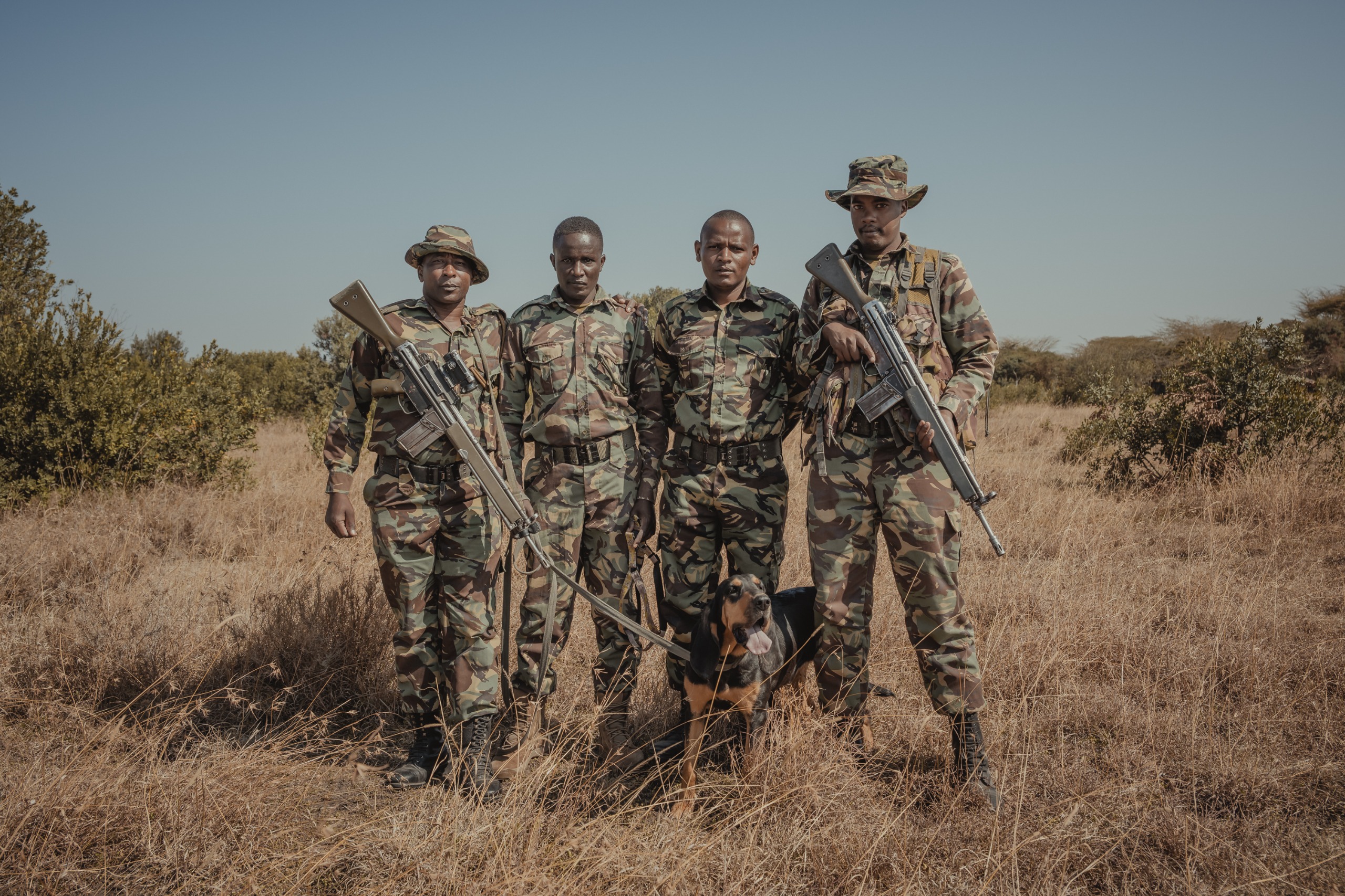A four-man armed patrol with rifles and tracking dog